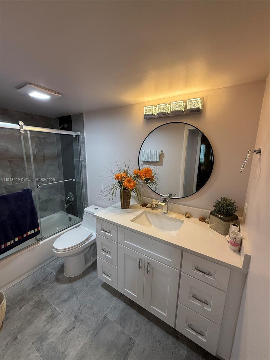 2022 Newcastle B, Unit 2022 Boca Raton, FL 33434 - Photo 20 of 21 a bathroom with a toilet sink and mirror