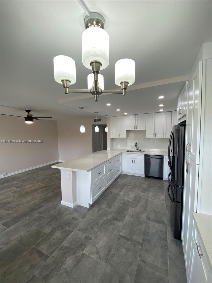 2022 Newcastle B, Unit 2022 Boca Raton, FL 33434 - Photo 2 of 21 a large kitchen with kitchen island stainless steel appliances lots of counter space and wooden floor