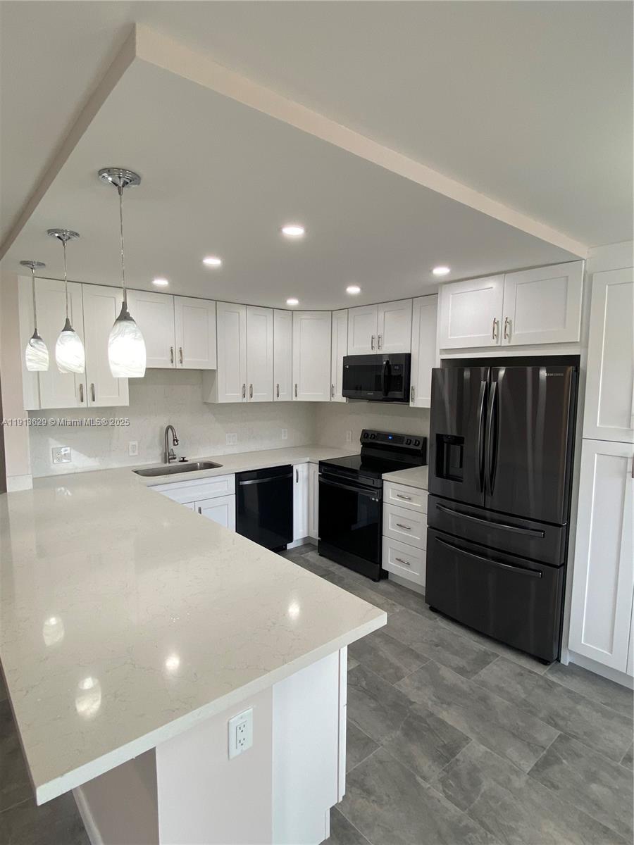 2022 Newcastle B, Unit 2022 Boca Raton, FL 33434 - Photo 5 of 21 a kitchen with granite countertop a refrigerator and a sink