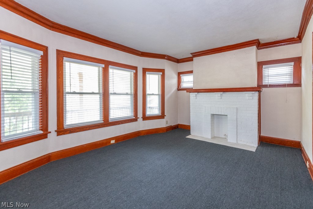917 Helmsdale Road Cleveland Heights, OH 44112 - Photo 4 of 28 Unfurnished living room with carpet, ornamental molding, and a fireplace