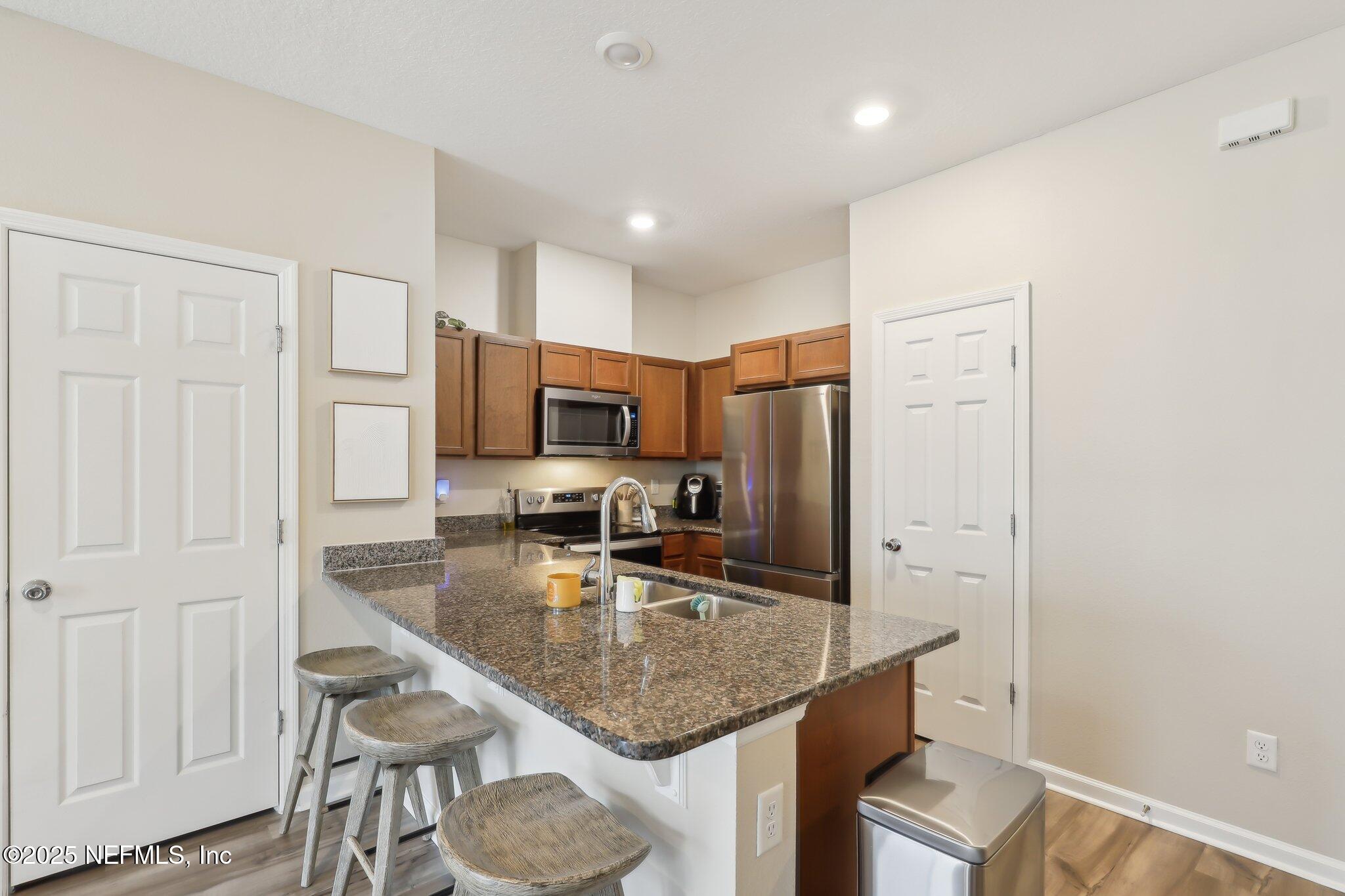 7738 Merchants Way Jacksonville, FL 32222 - Photo 11 of 29 a kitchen with stainless steel appliances granite countertop a sink refrigerator and microwave
