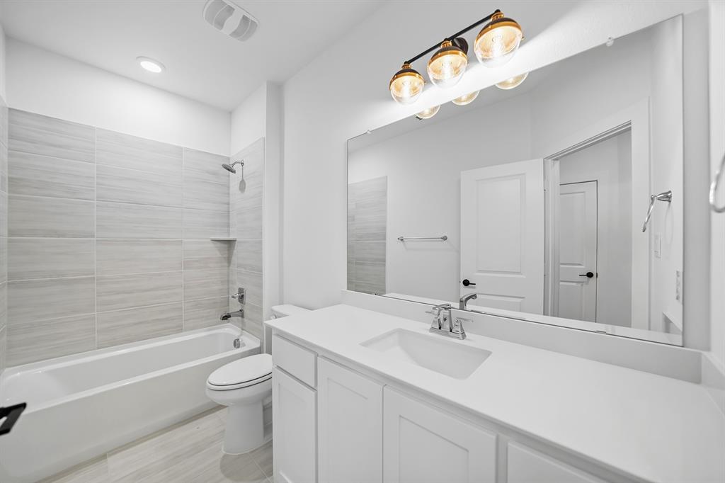 587 Mayfair Lane Frisco, TX 75033 - Photo 26 of 37 a bathroom with a sink a toilet and a bathtub