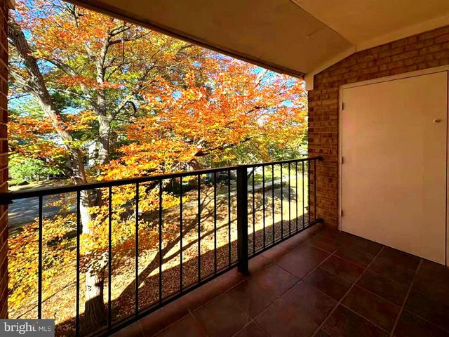 a view of an empty room with wooden floor and a bathroom