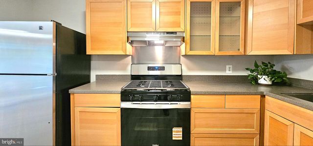 a kitchen with stainless steel appliances granite countertop a refrigerator a stove and a sink