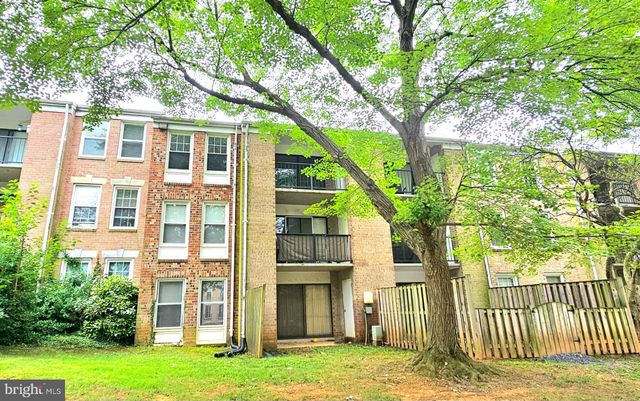 front view of a brick house with a large windows and a potted plant