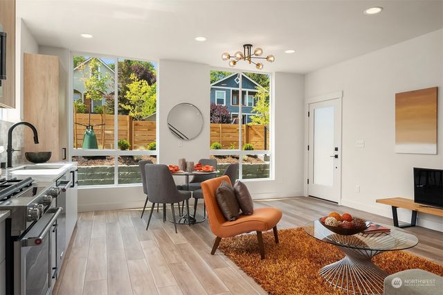 a living room with furniture a rug and a floor to ceiling window