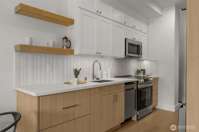 a kitchen with stainless steel appliances granite countertop a sink and a stove