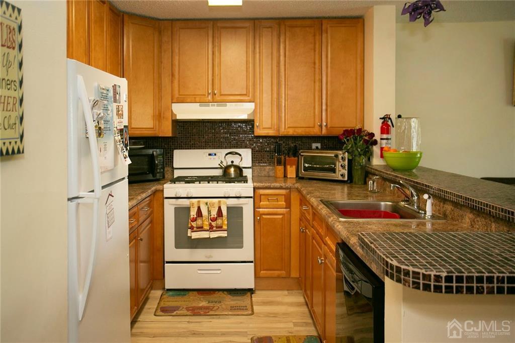 1213 Edpas Road New Brunswick, NJ 08901 - Photo 14 of 14 a kitchen with stainless steel appliances a stove a sink and a refrigerator