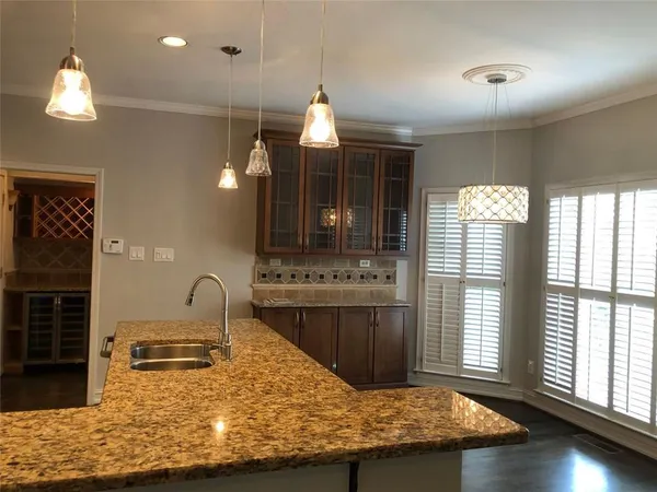 a kitchen with kitchen island granite countertop a sink and stainless steel appliances