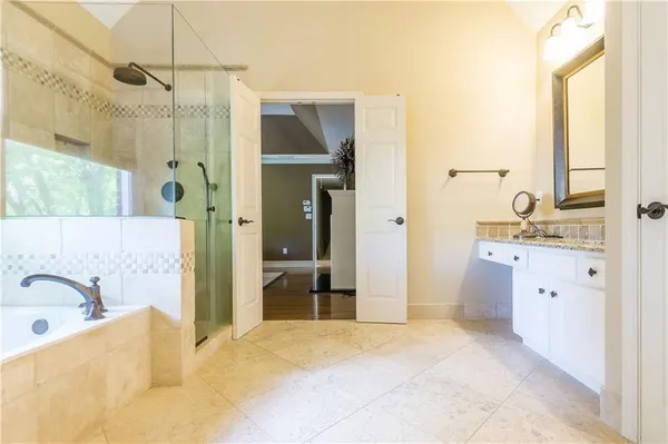 a bathroom with a tub sink and mirror