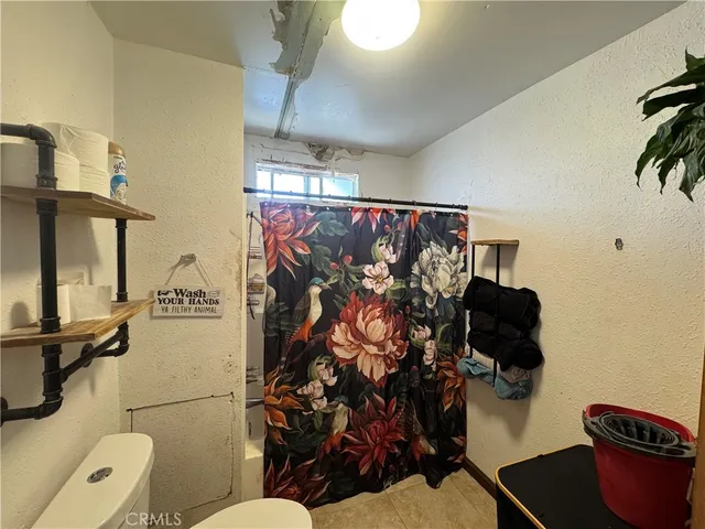 a bathroom with a toilet sink and shower curtain