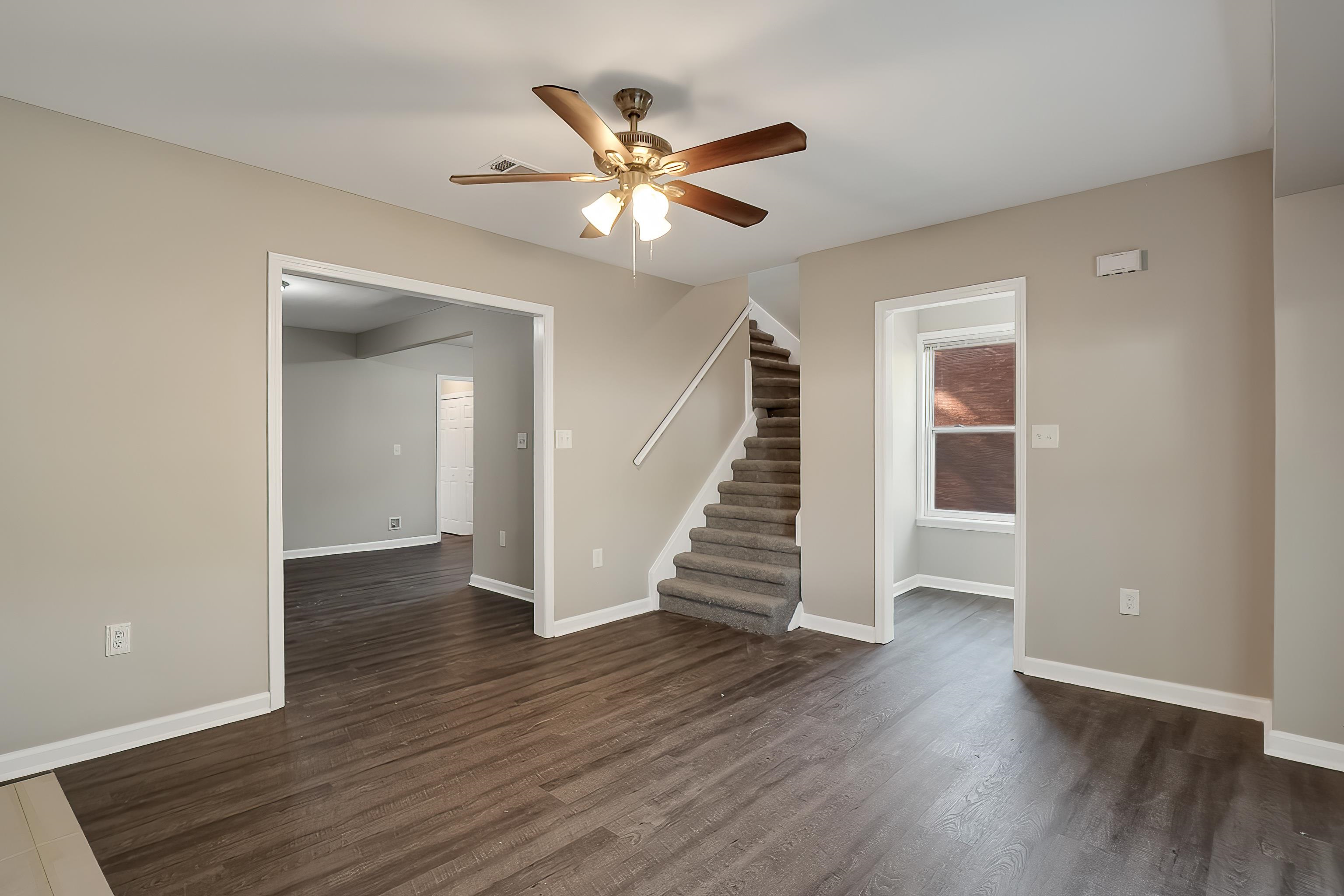 1019 Wingfield Road Memphis, TN 38122 - Photo 9 of 34 a view of an empty room with wooden floor and a ceiling fan