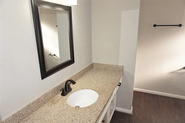 a bathroom with a granite countertop sink and a mirror