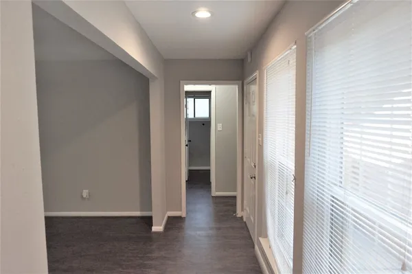 a view of a hallway with wooden floor