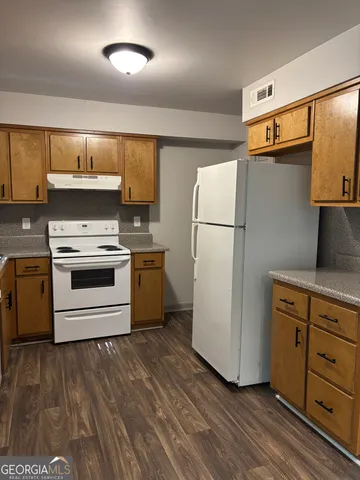 a kitchen with a refrigerator and a stove