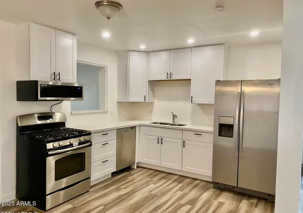 a kitchen with stainless steel appliances a stove a sink and a refrigerator