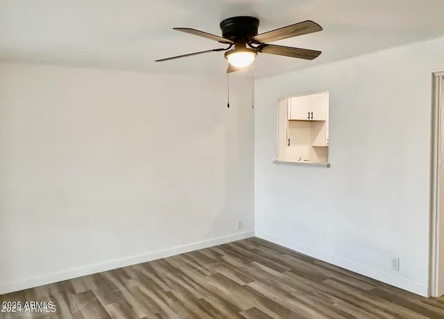 an empty room with a window and a fan