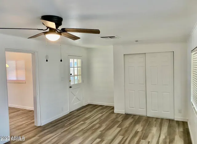 a view of empty room with wooden floor