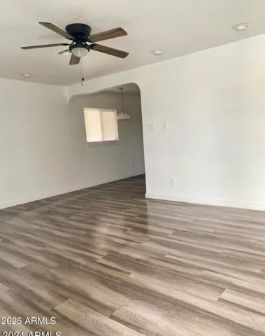 a view of room with a ceiling fan and wooden floor