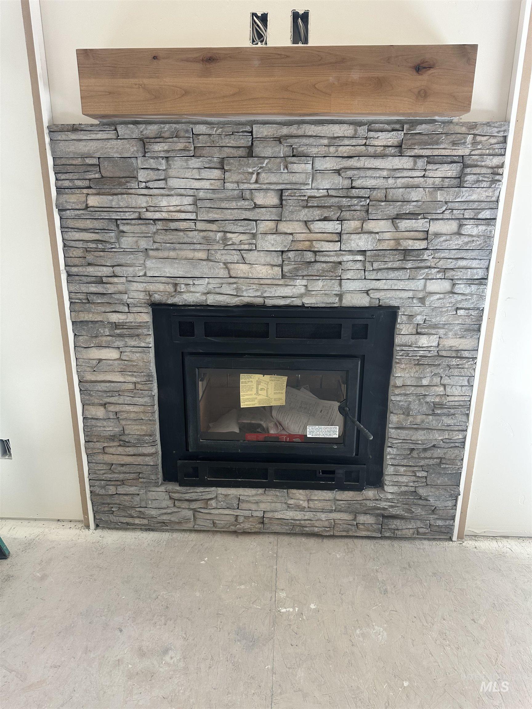 1760 Warren Wagon Road McCall, ID 83638 - Photo 4 of 5 Stone-clad fireplace with a wood mantel and a black firebox