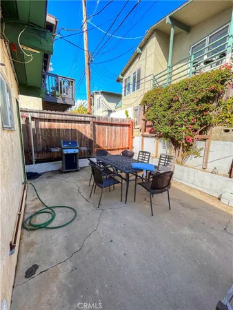 a backyard of a house with barbeque oven table and chairs