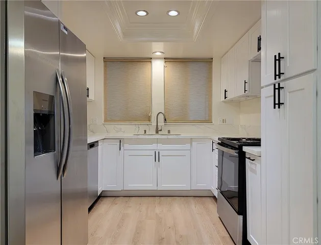 a kitchen with stainless steel appliances a refrigerator sink and stove