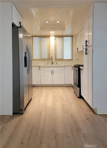 a view of a kitchen with a refrigerator and a sink