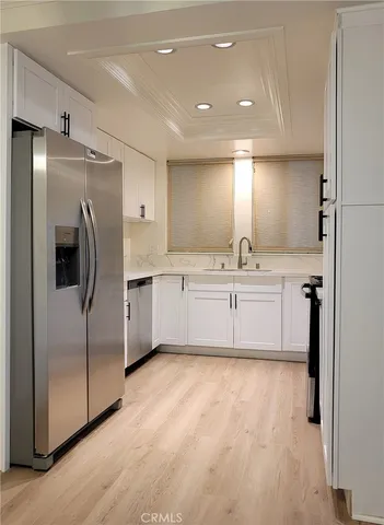 a large kitchen with a refrigerator a sink a stove and cabinets