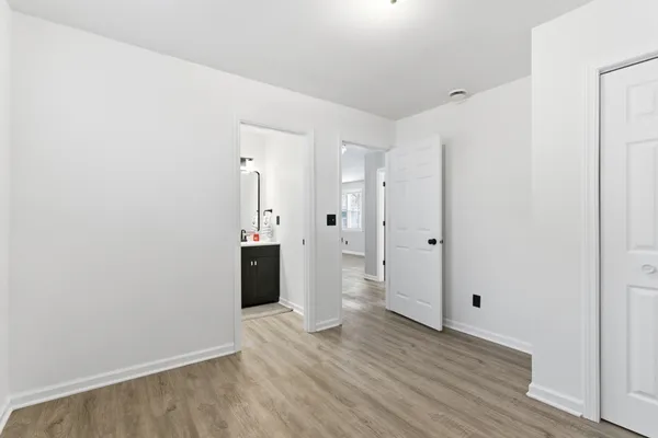 a view of a hallway with wooden floor and closet