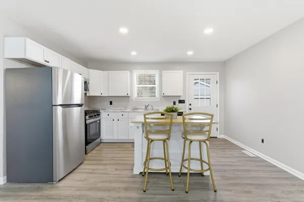 a kitchen with white cabinets and stainless steel appliances