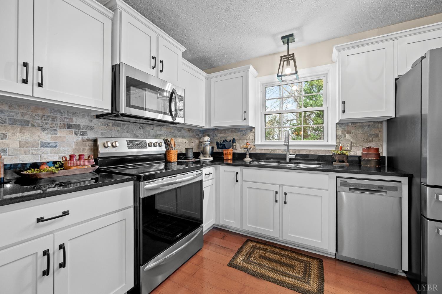 1136 Coolbrook Road Bedford, VA 24523 - Photo 15 of 46 a kitchen with stainless steel appliances granite countertop white cabinets a sink a window and a refrigerator