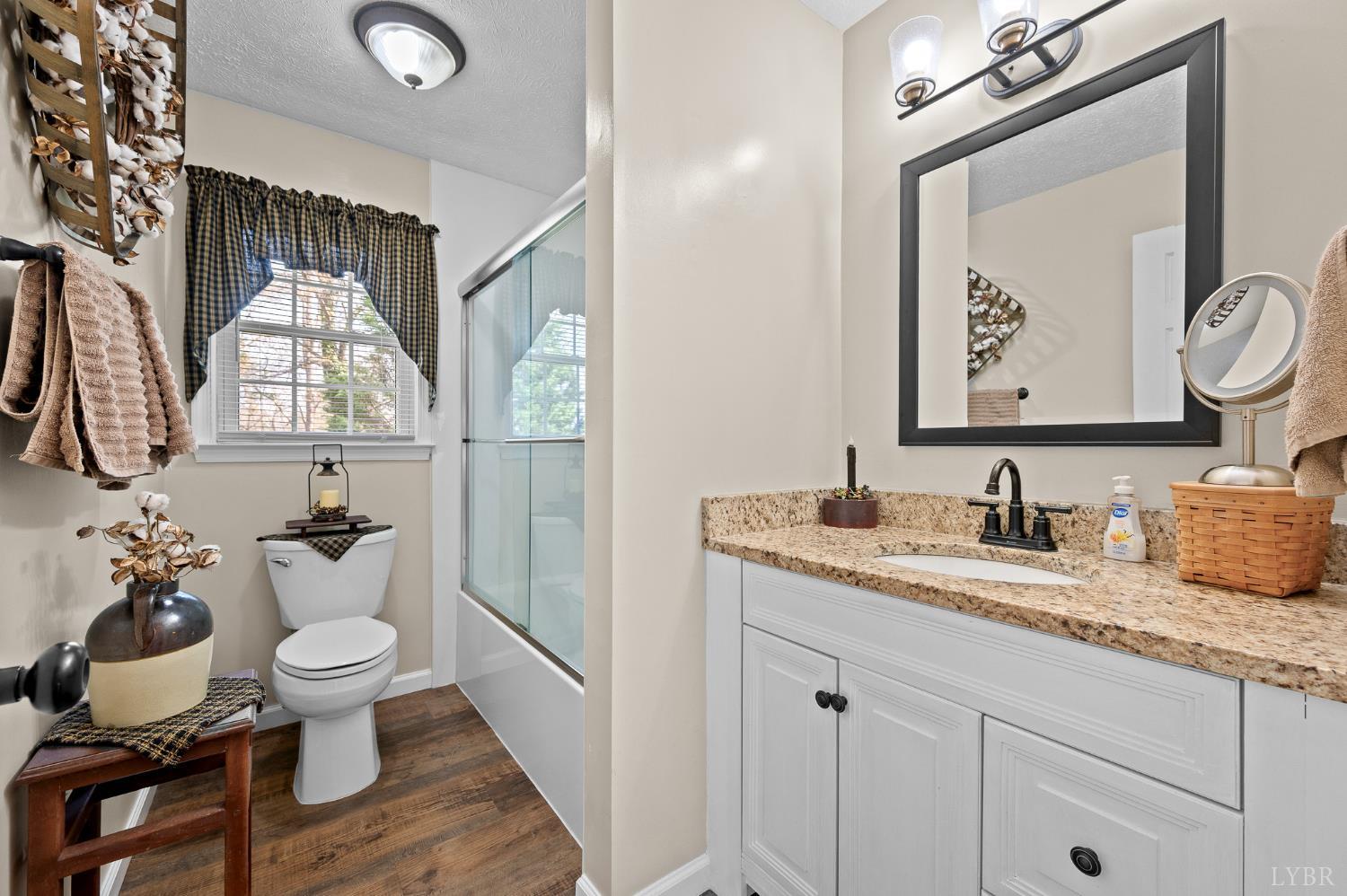 1136 Coolbrook Road Bedford, VA 24523 - Photo 17 of 46 a bathroom with a granite countertop sink mirror and toilet