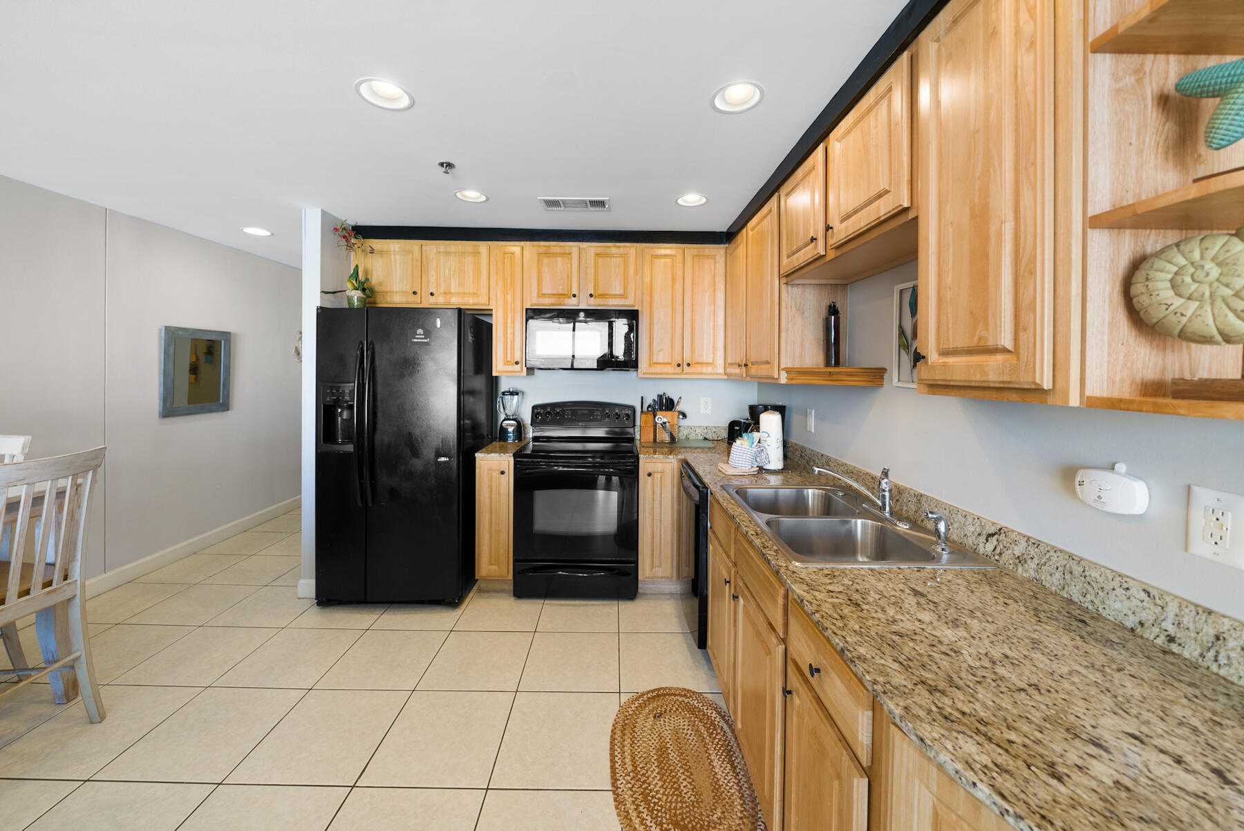 17729 Front Beach Road, Unit 702E Panama City Beach, FL 32413 - Photo 13 of 53 a kitchen with a sink a counter top space and stainless steel appliances
