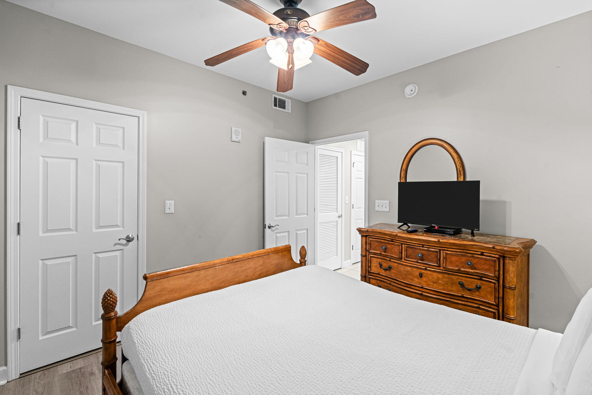17729 Front Beach Road, Unit 702E Panama City Beach, FL 32413 - Photo 23 of 53 a bedroom with a bed and a dresser with a chandelier
