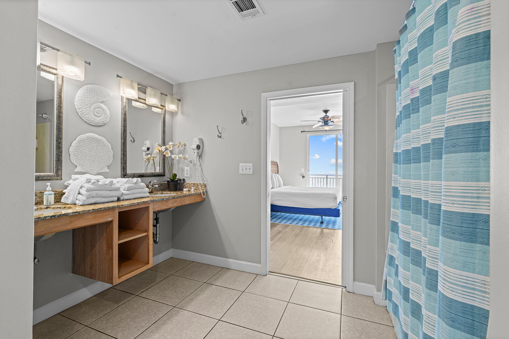 17729 Front Beach Road, Unit 702E Panama City Beach, FL 32413 - Photo 26 of 53 a spacious bathroom with a granite countertop sink a mirror and shower