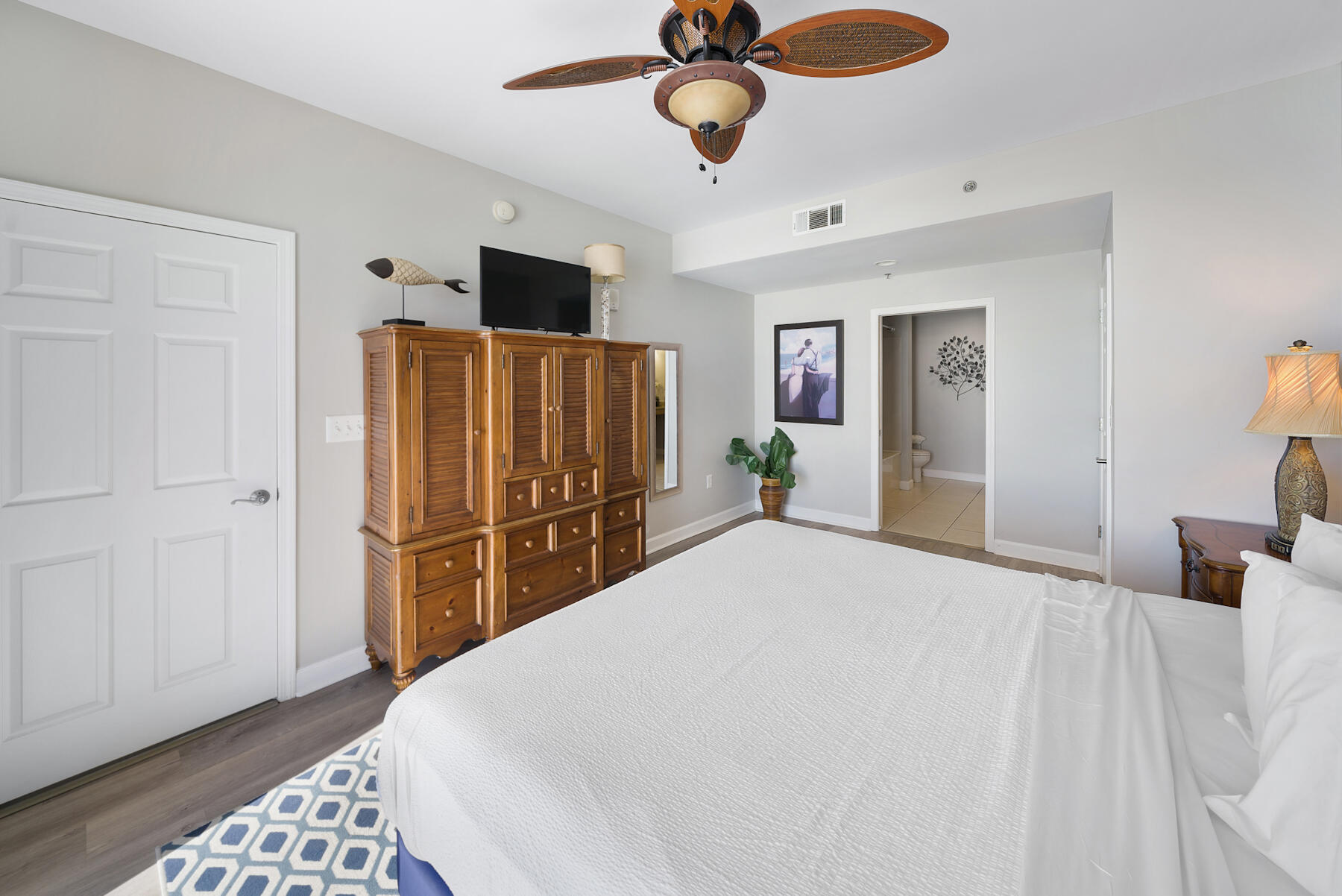 17729 Front Beach Road, Unit 702E Panama City Beach, FL 32413 - Photo 33 of 53 a bedroom with a bed and wooden floor
