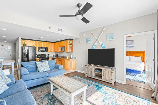 a living room with furniture kitchen view and a chandelier