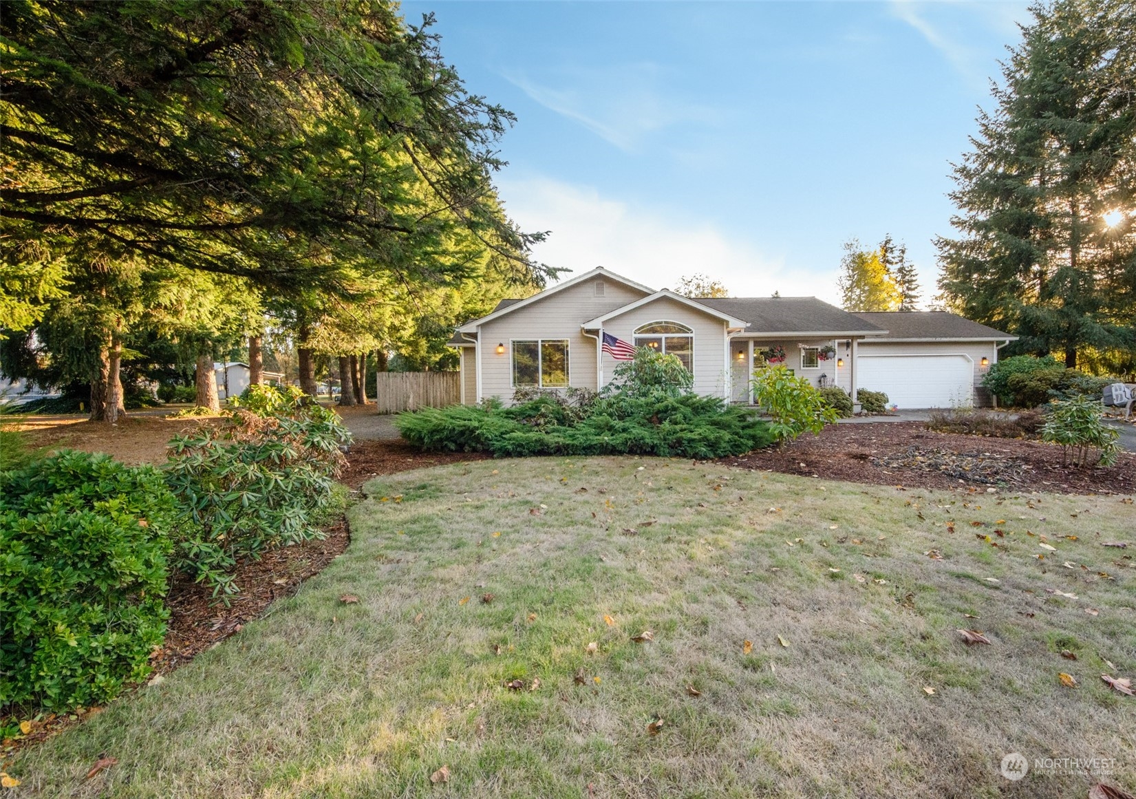 a front view of a house with a yard and trees