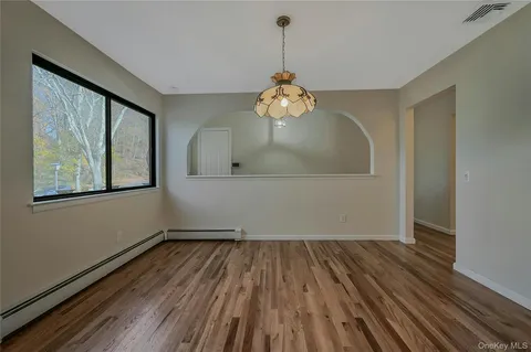 a view of a room with wooden floor and a ceiling fan