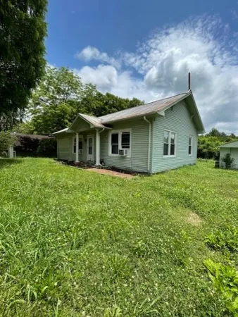 a view of a house with a yard and potted plants
