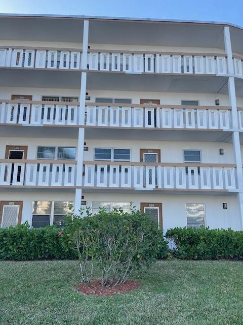 2075 Cornwall East, Unit 2075 Boca Raton, FL 33434 - Photo 2 of 32 a front view of a residential apartment building with a yard