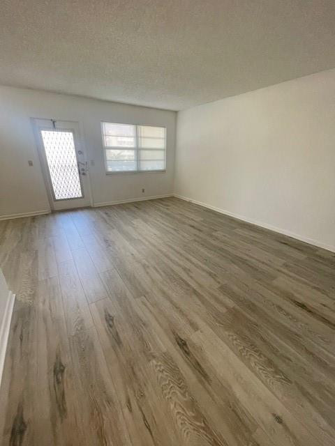 2075 Cornwall East, Unit 2075 Boca Raton, FL 33434 - Photo 8 of 32 an empty room with wooden floor and windows