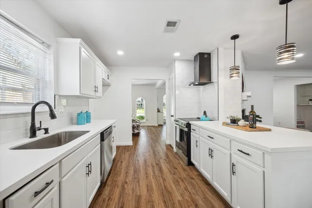 a kitchen with sink stove and cabinets
