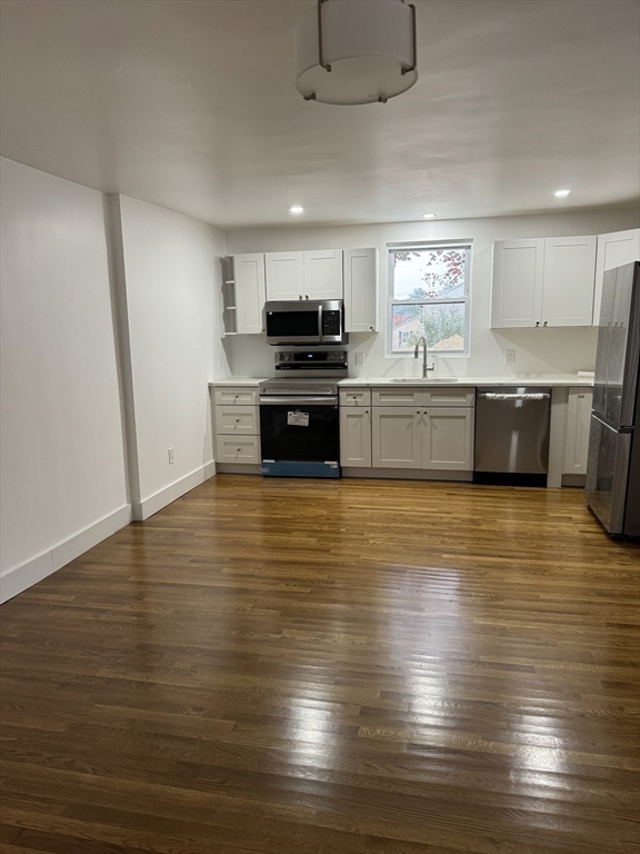 1099 South Main Street Bellingham, MA 02019 - Photo 9 of 20 a kitchen with stainless steel appliances wooden cabinets large counter space and wooden floor