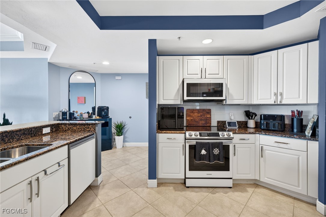 2743 First Street, Unit 502 Fort Myers, FL 33916 - Photo 11 of 39 a kitchen with stainless steel appliances granite countertop a stove a sink and a microwave