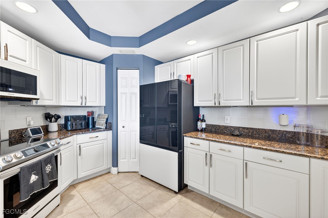 2743 First Street, Unit 502 Fort Myers, FL 33916 - Photo 12 of 39 a kitchen with granite countertop white cabinets and white appliances