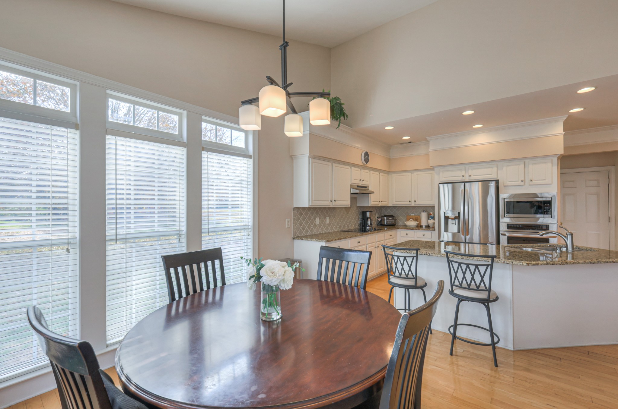 6331 Williams Grove Drive Brentwood, TN 37027 - Photo 9 of 58 a dining room with wooden floor a chandelier a wooden table and chairs