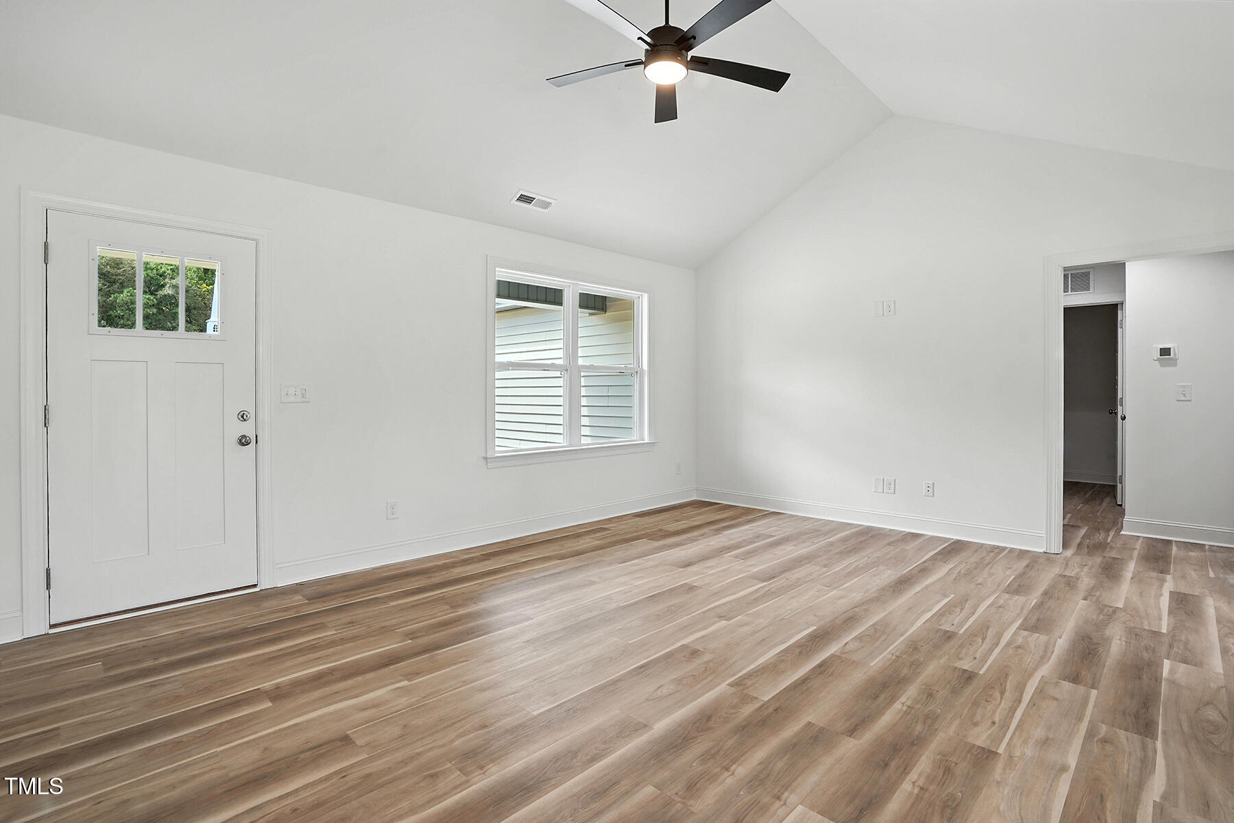 8708 Green Path Road Dunn, NC 28334 - Photo 8 of 31 a view of an empty room with wooden floor and a window