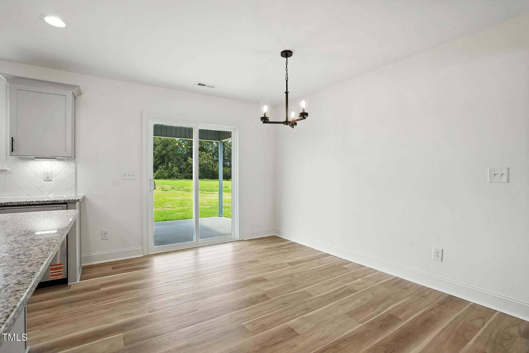 8708 Green Path Road Dunn, NC 28334 - Photo 10 of 31 a view of an empty room with a window and wooden floor