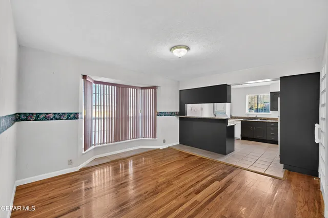 a view of a kitchen with wooden floor and electronic appliances